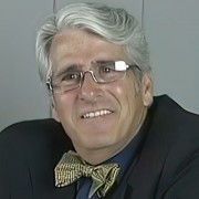 Man with silver hair and glasses